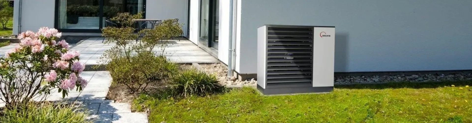 Solvis Wärmepumpe steht im Garten an der Hauswand