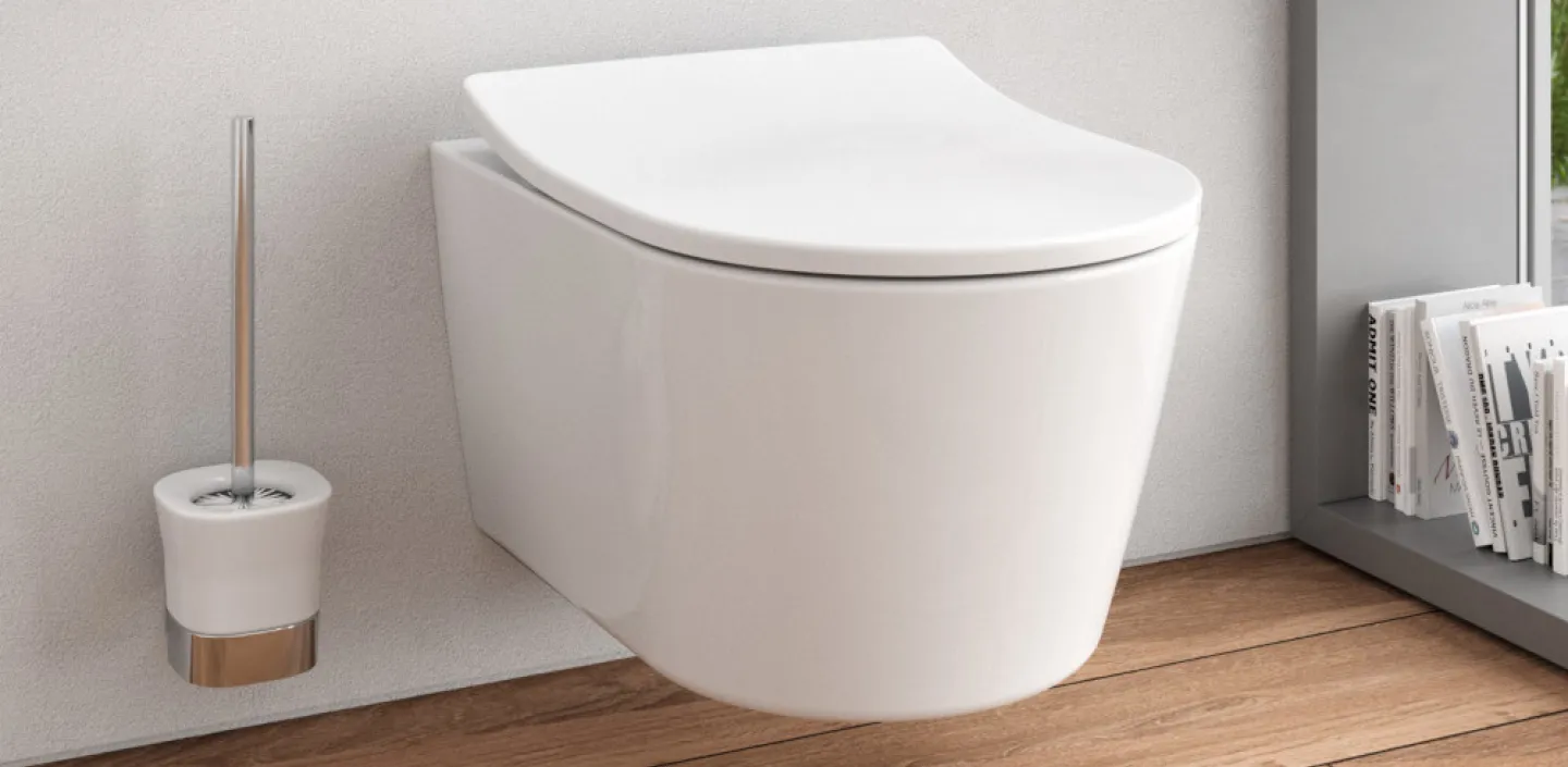 Ein modernes Badezimmer mit einer wandmontierten, weißen Toilette und einem geschlossenen Deckel.