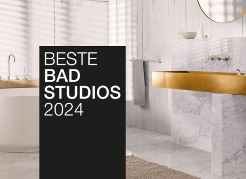 Ein stilvolles Bad mit goldenen Armaturen, Marmorwaschtisch und freistehender Badewanne. Ein schwarzer Banner mit "Beste Badstudios 2024" ist prominent im Bild.