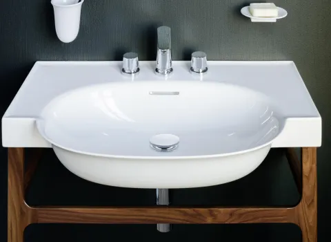 Ein modernes, weißes Waschbecken mit abgerundeten Kanten steht auf einem eleganten Holzgestell.