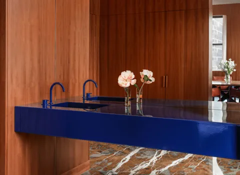 Badezimmer mit hölzerner Wand und dunkelblauem Waschtisch sowie blaue Wasserhähne von VOLA