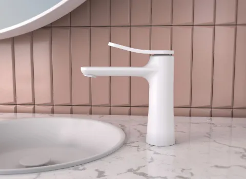 Die Frattini FLÒ Waschtischarmatur in mattem Weiß steht auf einer eleganten Marmorplatte neben einem runden Waschbecken.