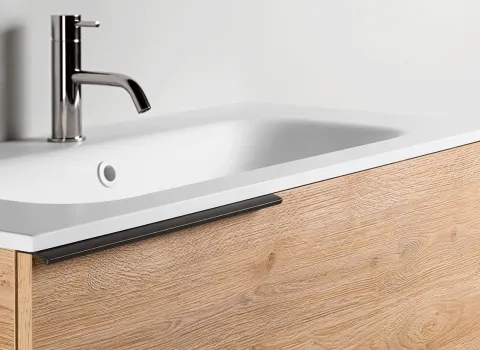 Detail eines Stocco Waschtischs mit heller Holzfront, weißem Becken und schlankem Griffprofil.