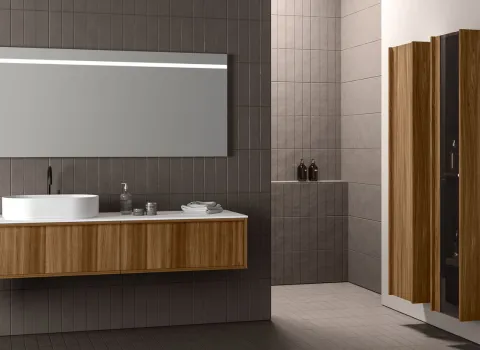 Badmöbel von Stocco mit Unterschrank in Holzoptik, schwarzer Armatur, großem Spiegel und hohem Stauraumschrank.