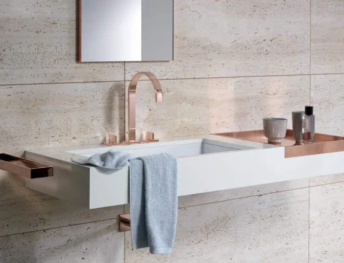 An Naturstein hängender Waschtisch mit einer Armatur in rosengold