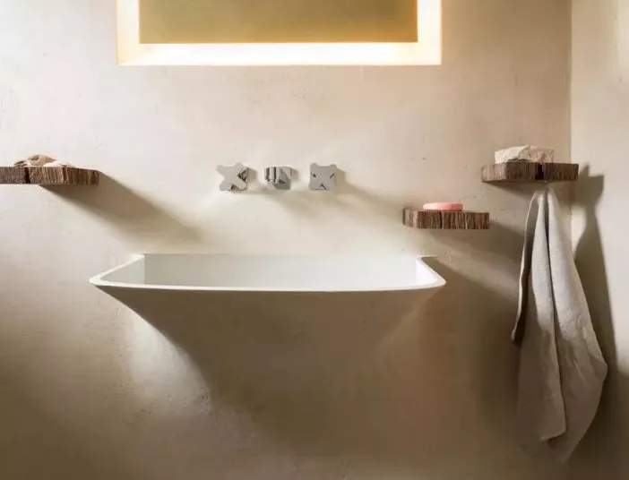 Silberne Armatur über Waschbecken aus matt weißem Mineralwerkstoff